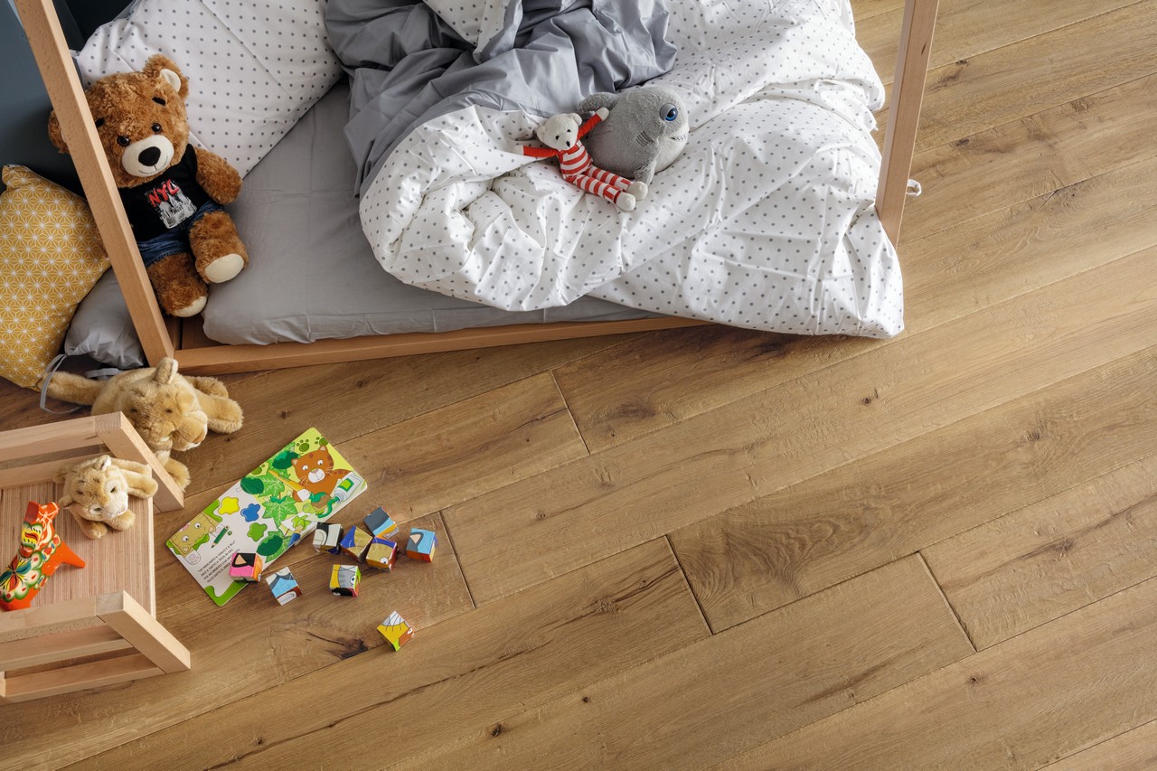 Shabby bedroom with wood-effect flooring in shades of beige and brown.