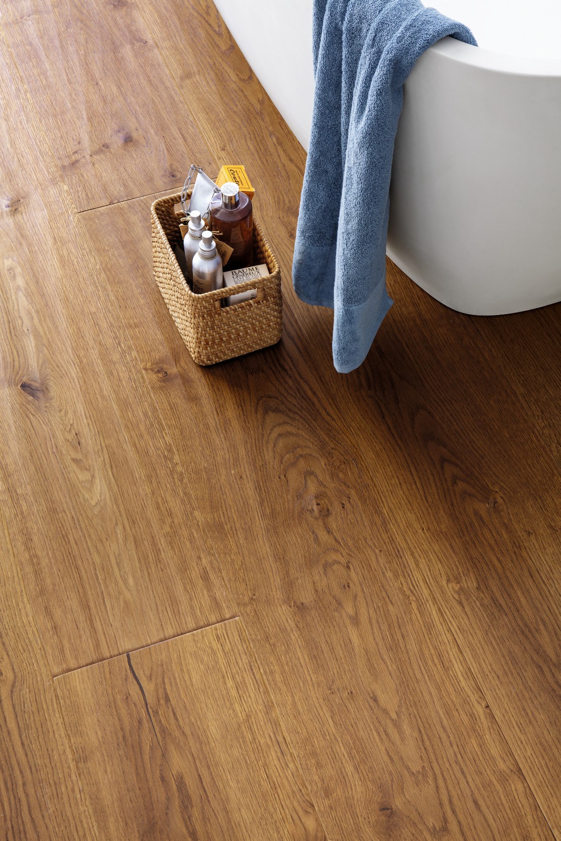 Modern bathroom with bathtub and brown wood flooring.