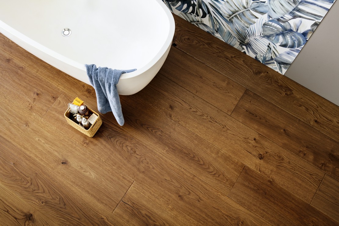 Salle de bains moderne avec baignoire, sol en bois et carrelage mural effet papier peint bleu - Inspirations Iperceramica