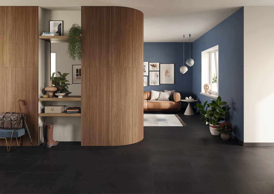 Soggiorno moderno di lusso con pavimento effetto pietra nera e rivestimento in legno elegante - Ambienti Iperceramica