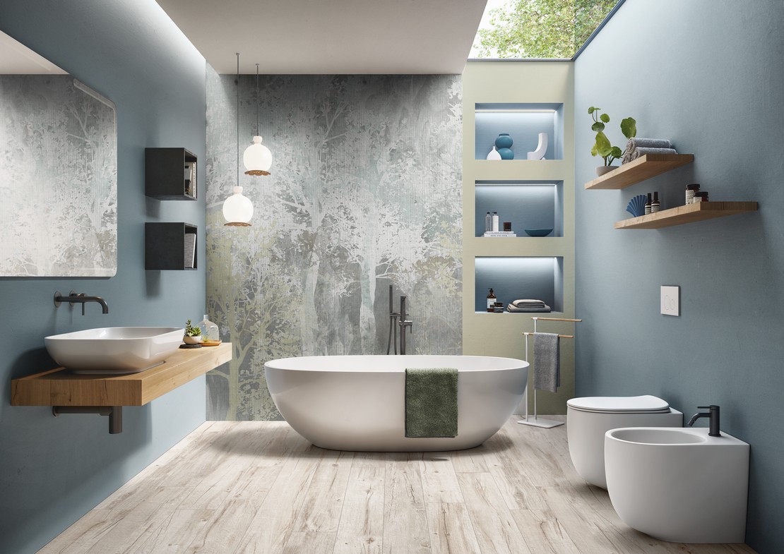 Salle de bains moderne avec baignoire, papier peint et sol effet bois - Inspirations Iperceramica