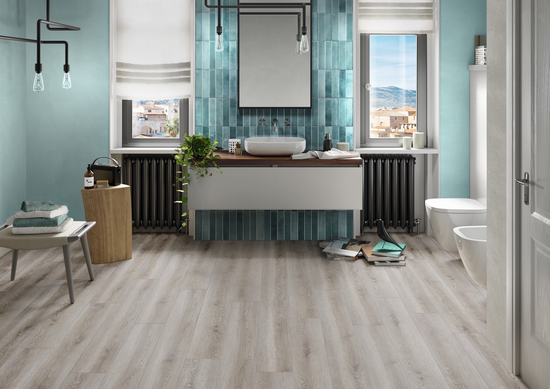 Salle de bains moderne avec sol imitation bois pour une touche industrielle et revêtement bleu - Inspirations Iperceramica