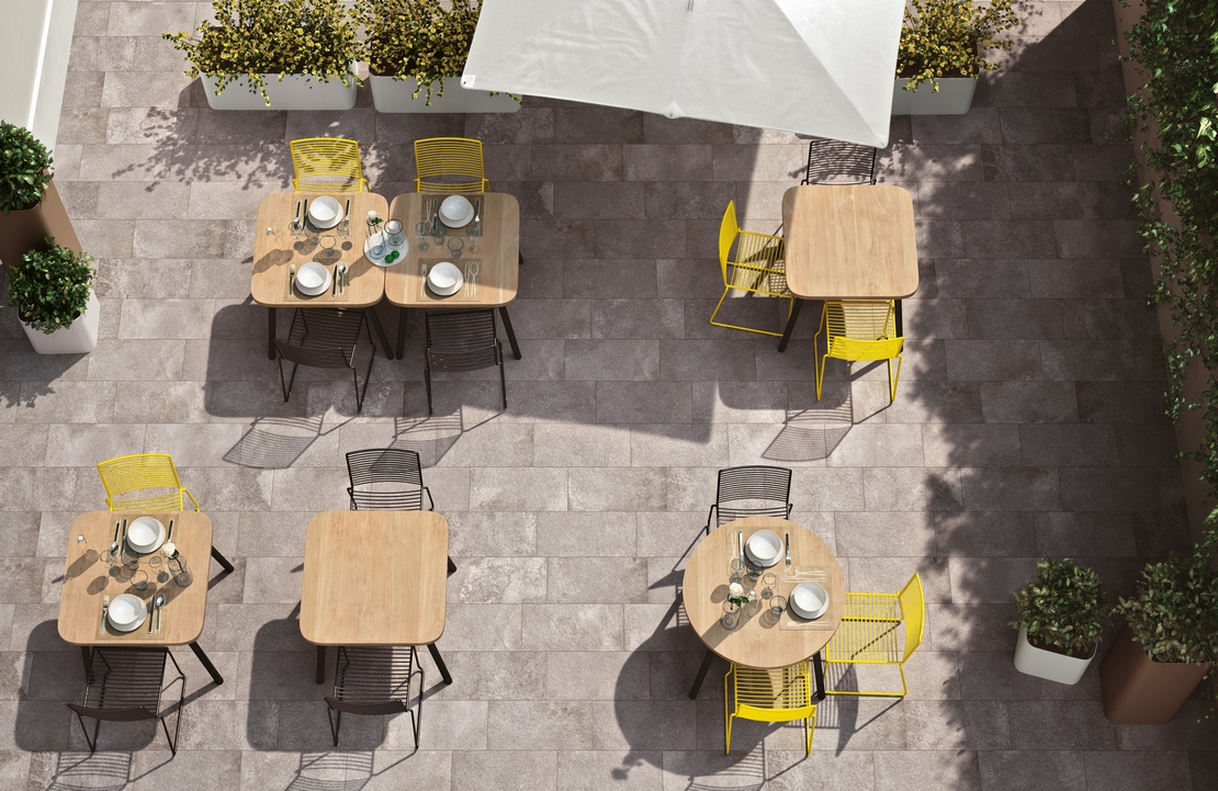 Terrasse de bar-restaurant moderne avec sol imitation pierre et tons gris. - Inspirations Iperceramica