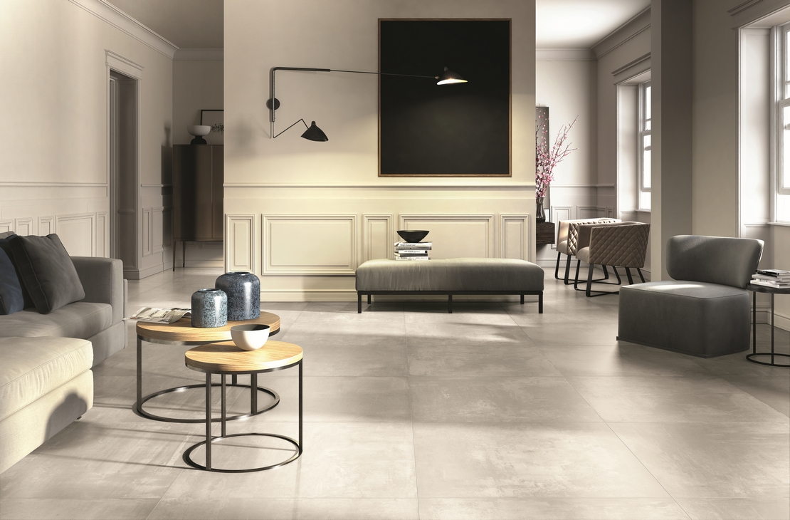Soggiorno elegante, pavimento effetto resina grigio, toni beige per un tocco di lusso - Ambienti Iperceramica