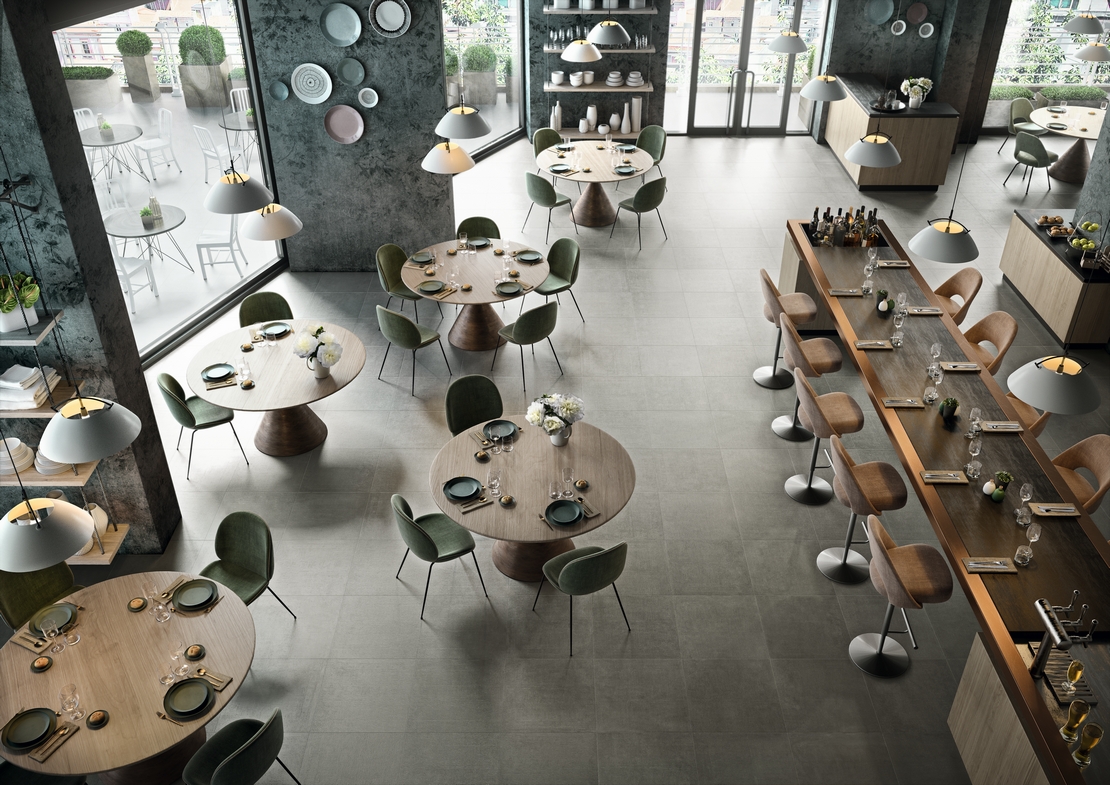 Ristorante-Bar moderno con pavimento in gres effetto cemento grigio per un tocco industriale - Ambienti Iperceramica