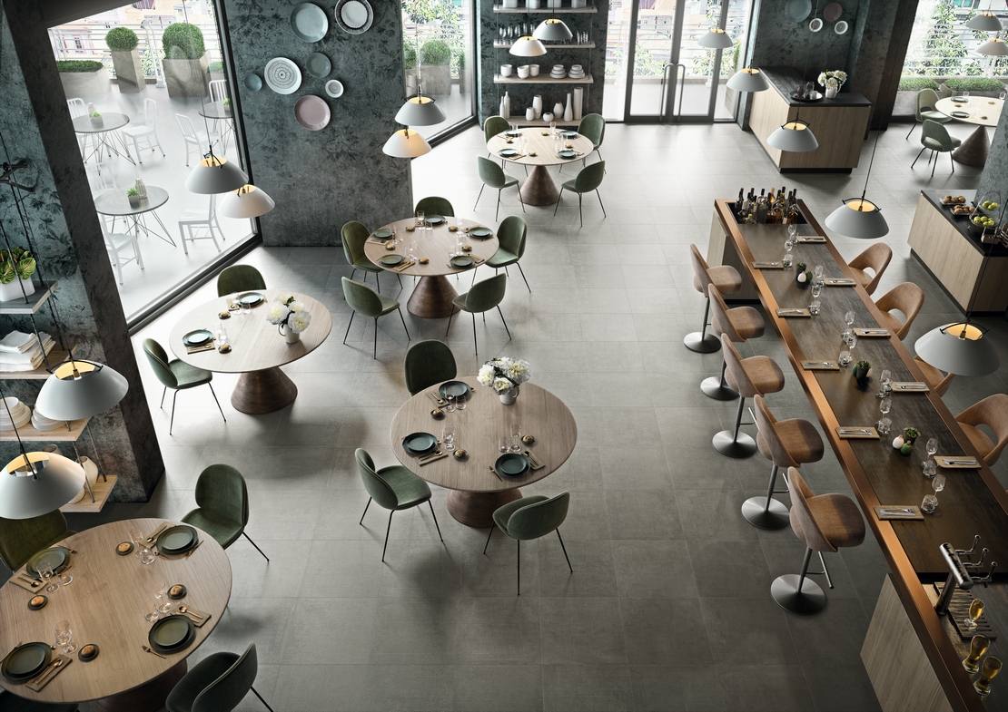 Modern restaurant bar with gray concrete-effect stoneware flooring for an industrial touch