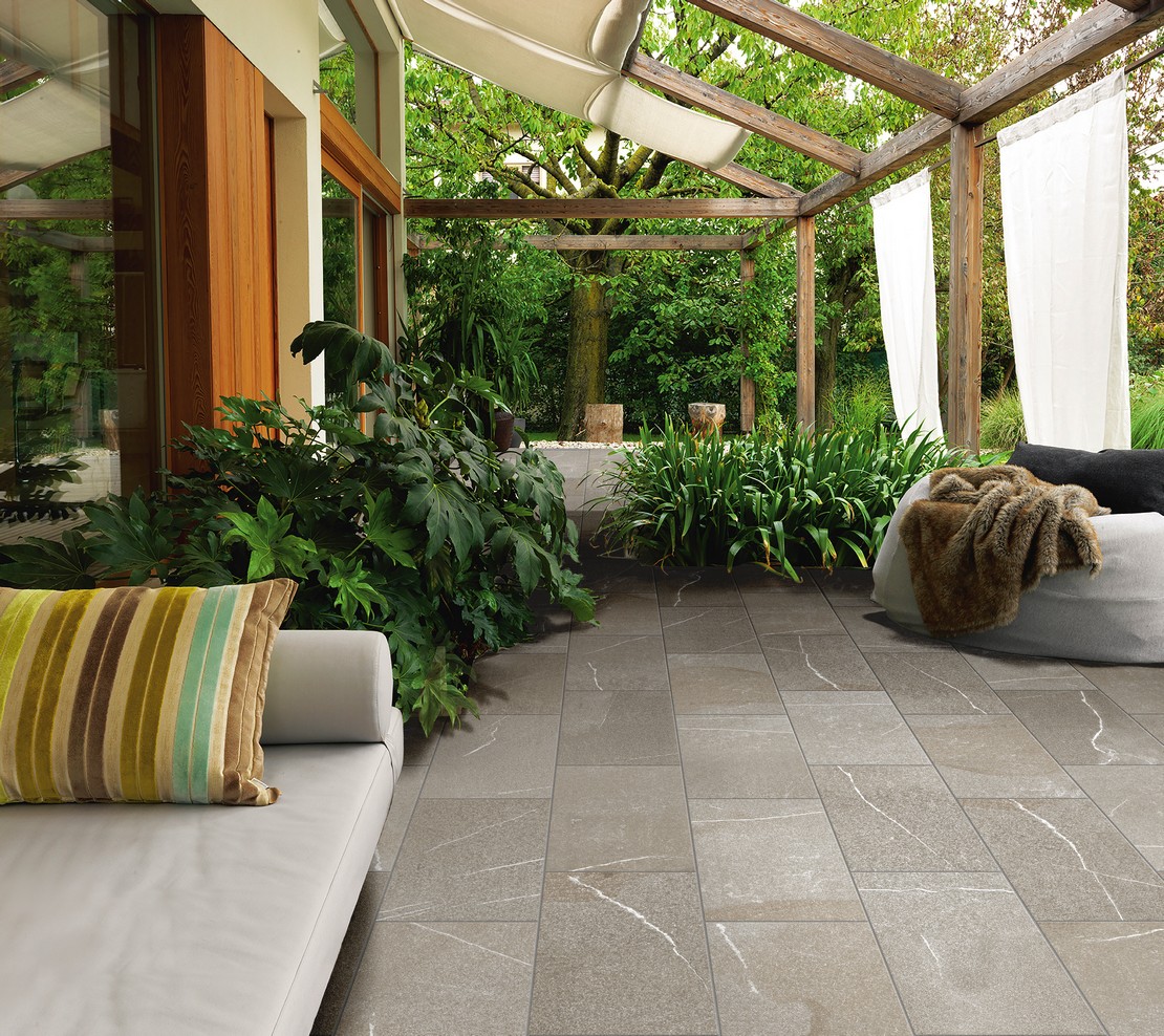 Patio in stile tradizionale con pavimento effetto pietra grigio - Ambienti Iperceramica