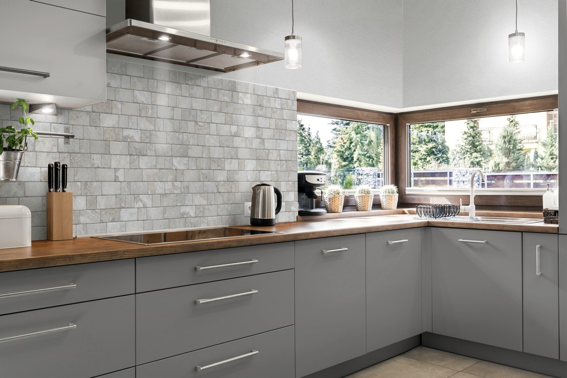 Cucina moderna ad angolo con rivestimento effetto pietra grigio - Ambienti Iperceramica