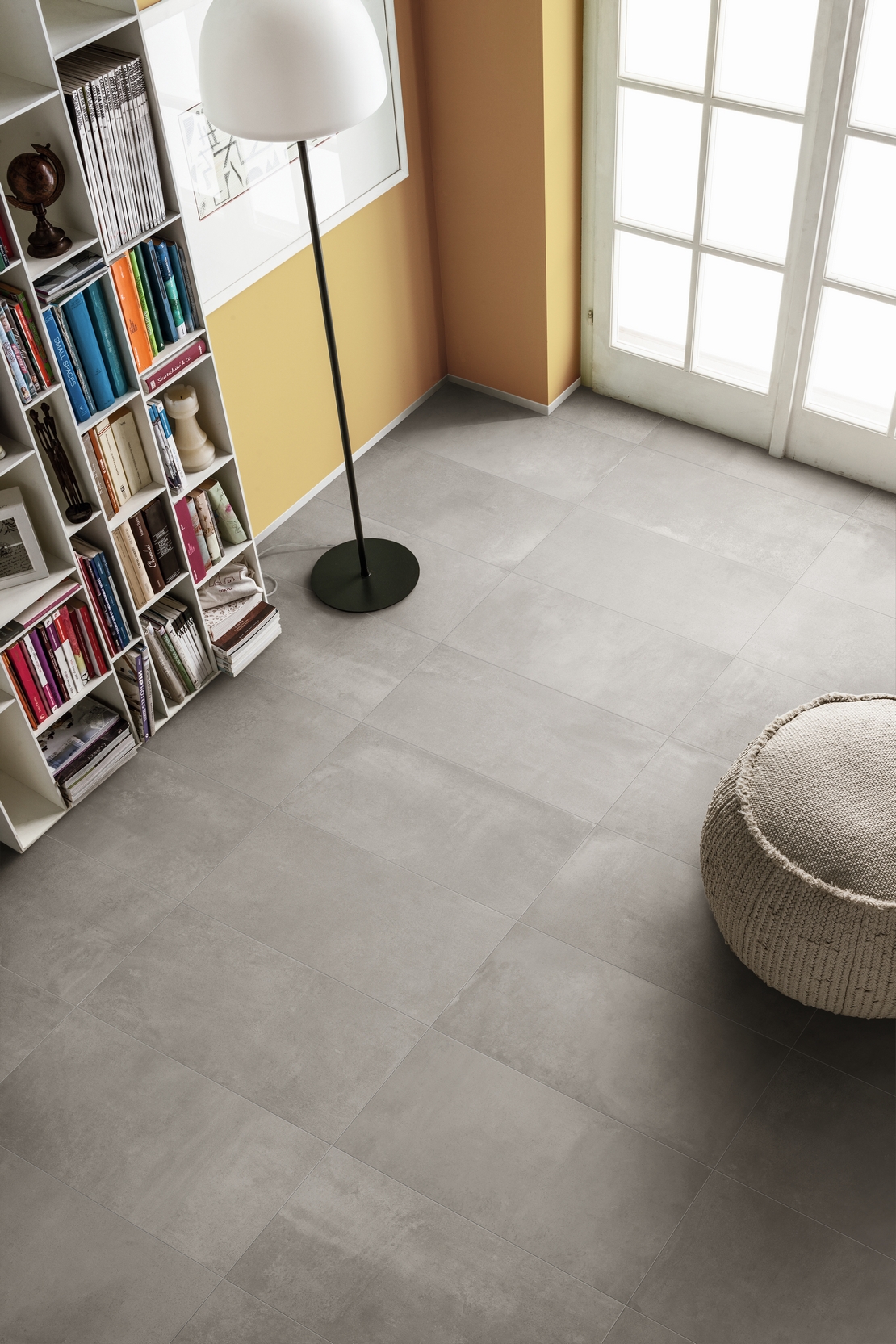 Séjour moderne : sol en grès cérame effet béton gris, tons de jaune pour une touche minimaliste. - Inspirations Iperceramica