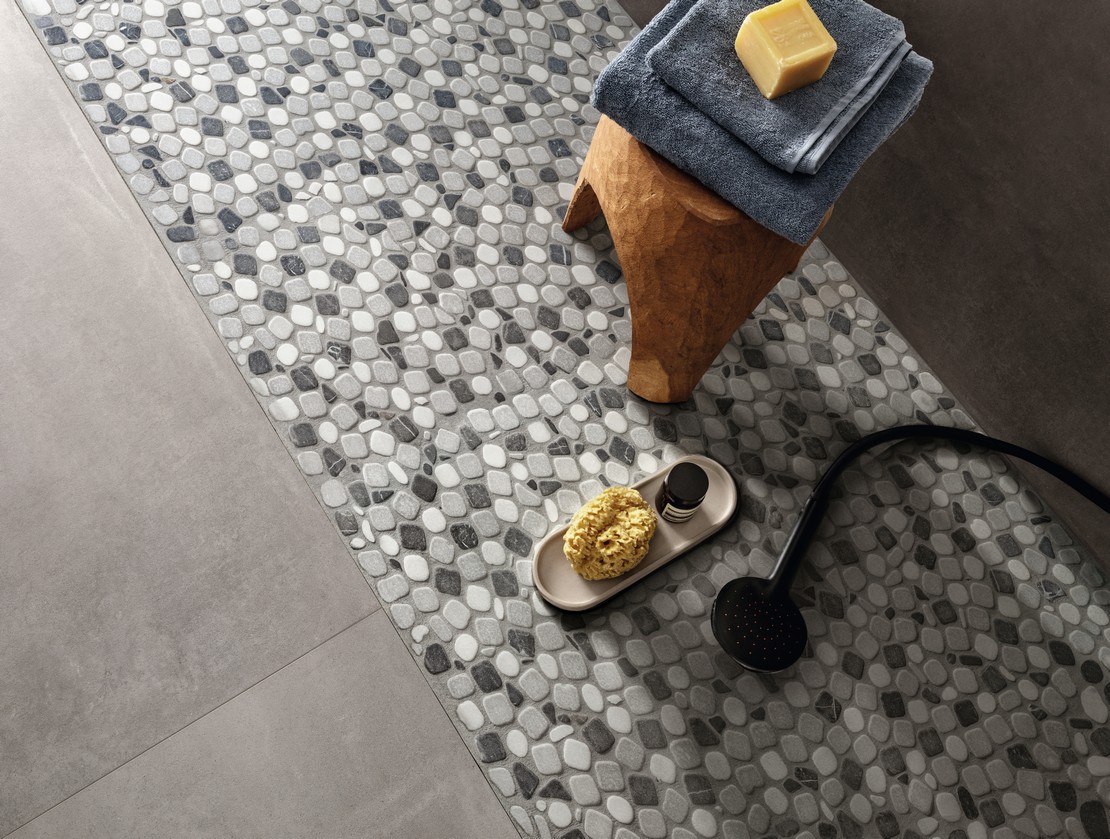 Modern rustic bathroom, marble mosaic shower, concrete-effect flooring and wall tiles.