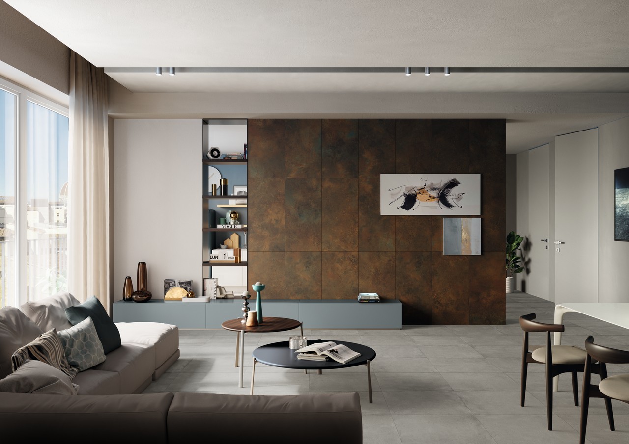 Modernes Wohnzimmer mit Boden in grauer Zementoptik und Wandverkleidung in Metalloptik - Inspirationen Iperceramica