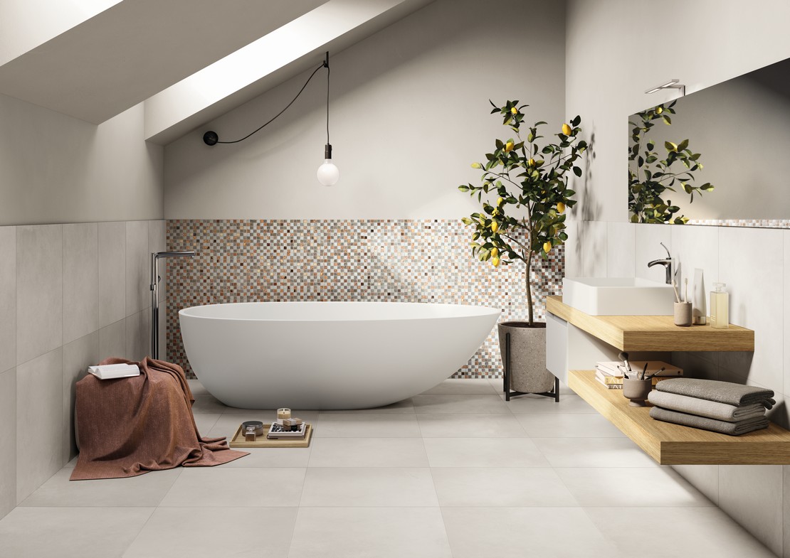 Salle de bains minimaliste luxueuse avec baignoire, mosaïque rose et or, sol et murs effet béton - Inspirations Iperceramica