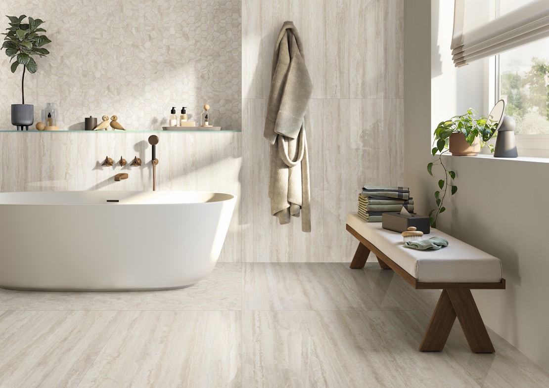 Elegant bathroom with bathtub, white travertine marble effect flooring and wall tiles