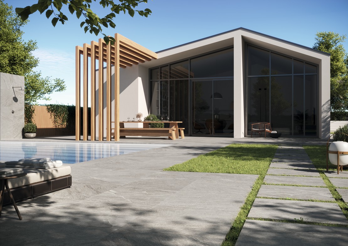 Giardino con piscina in stile moderno e pavimento effetto pietra - Ambienti Iperceramica