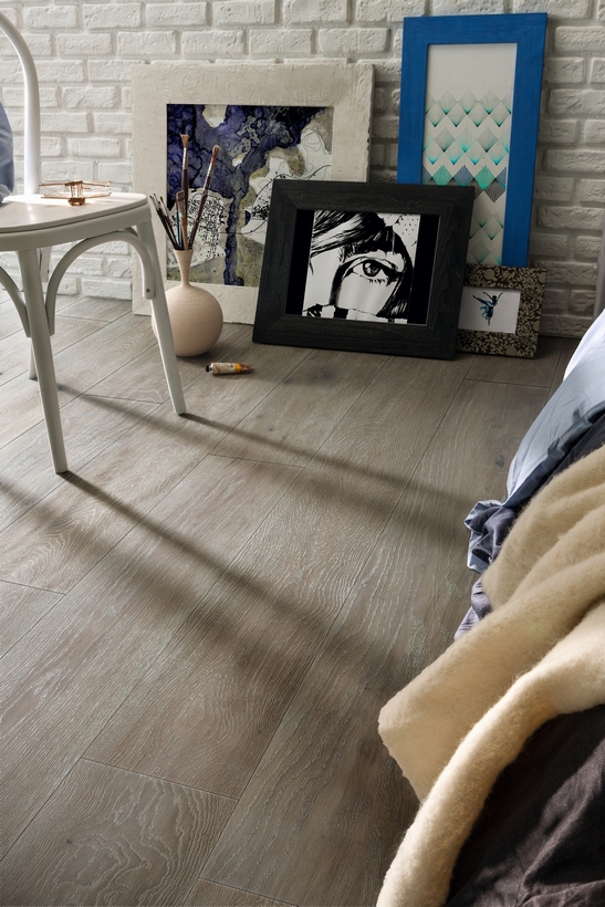 Rustic and modern industrial-style bedroom with gray parquet flooring
