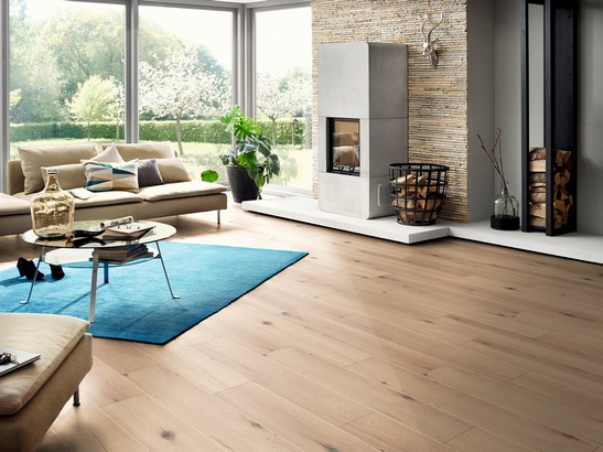 Séjour moderne rustique avec sol effet bois dans des tons de beige.