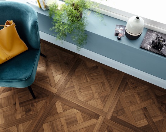 Séjour chic avec parquet effet bois et mur dans les tons de bleu.