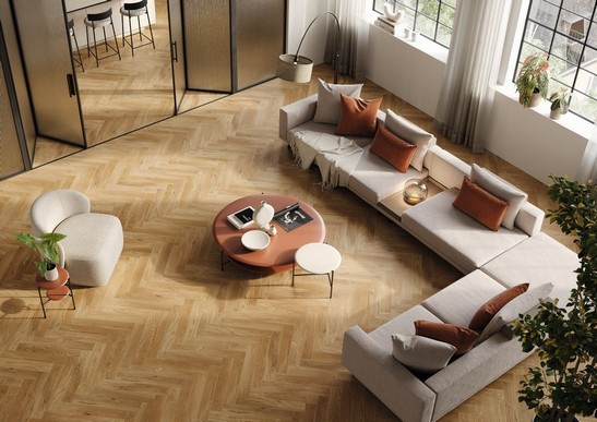 Modern living room in warm tones with herringbone wood flooring