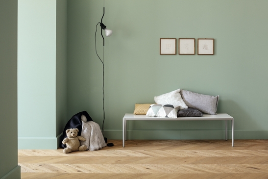 Séjour moderne : sol effet bois et mur vert menthe pour une touche minimaliste.