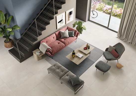 Elegantes Wohnzimmer mit Zementoptik Boden und an den Wänden blau und beige Töne