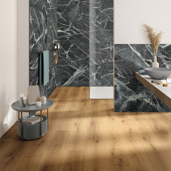 Bagno moderno di lusso con rivestimento effetto marmo verde e pavimento effetto legno