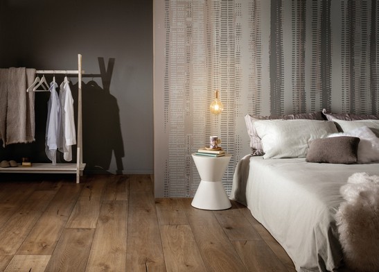 Modern minimalist-style bedroom with wallpaper and parquet flooring.