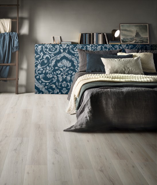 Colorful shabby bedroom with wood-effect flooring.