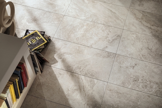 Séjour rustique, sol en grès cérame effet pierre et tons de gris.