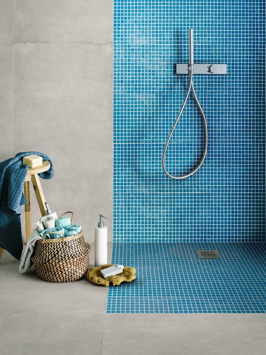 Petite salle de bains colorée de style industriel avec douche en mosaïque bleue et sol effet béton 