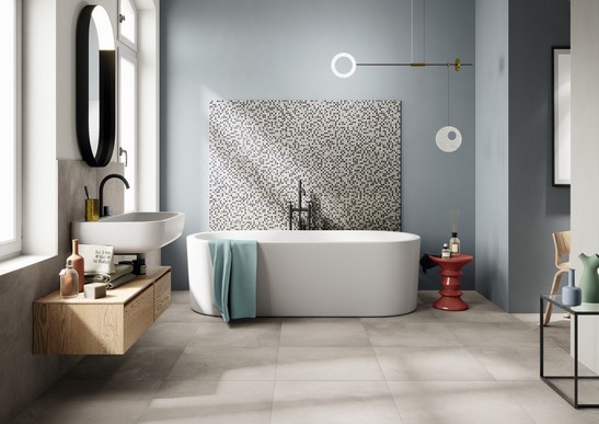 Salle de bains de luxe colorée avec baignoire, sol et carrelage mural en béton et mosaïque grise