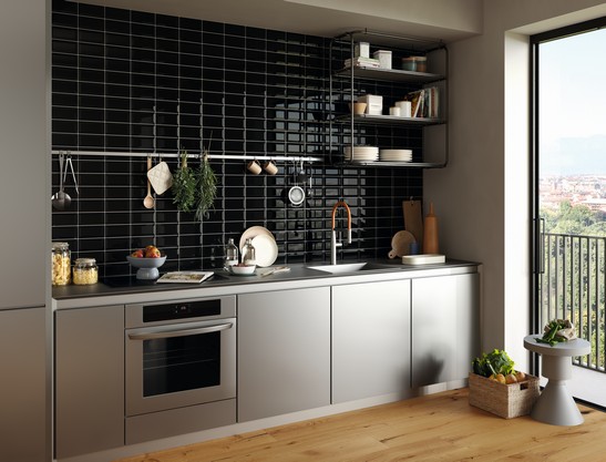 Kleine, moderne, lineare Küche im minimalistischen und industriellen Stil mit schwarzen Fliesen