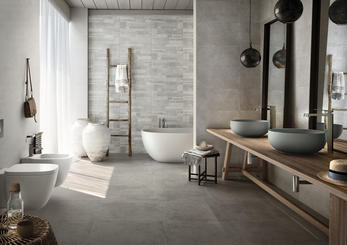 Bagno moderno con vasca. Effetto pietra e cemento per uno stile rustico e di lusso