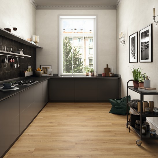 Cucina ad angolo moderna con pavimento effetto legno beige e piastrelle nere