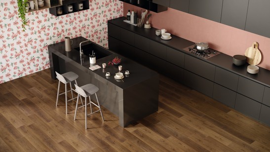 Cuisine moderne avec îlot central, sol PVC renforcé effet bois et murs dans des tons roses.
