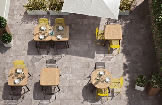 Modern outdoor restaurant bar with stone-effect flooring and shades of gray