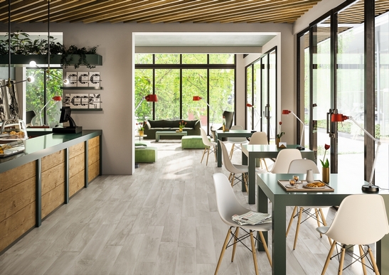 Terrasse de bar-restaurant moderne avec sol en grès cérame imitation bois gris et tons de blanc.