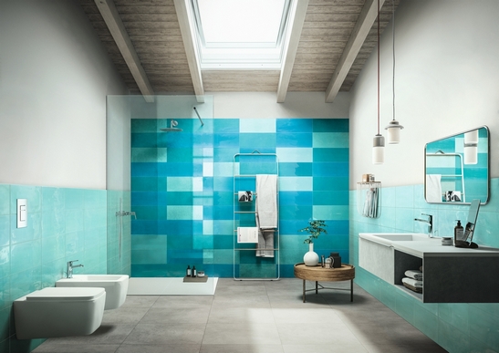 Salle de bains moderne avec douche. Effet béton gris, mur turquoise et vert d’eau.
