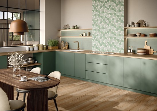 Cucina moderna dai toni caldi con pavimento effetto legno e rivestimento verde effetto carta da parati