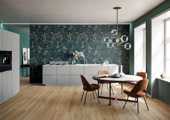 Cuisine moderne avec grès cérame effet papier peint aux tons verts et sol imitation bois.