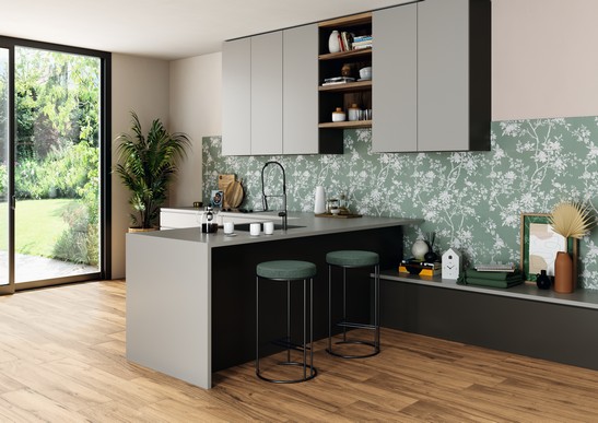 Cuisine moderne avec grès cérame effet papier peint floral vert et sol effet bois.
