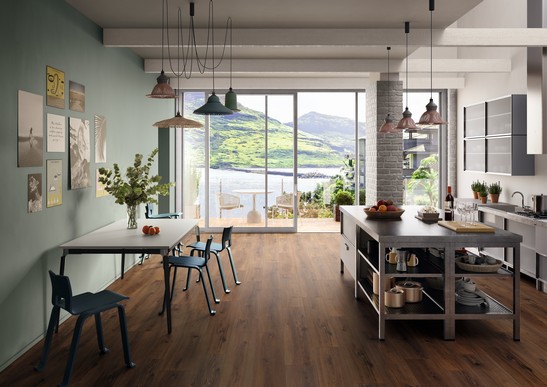 Cucina moderna in stile indutrial con isola e pavimento effetto legno marrone scuro