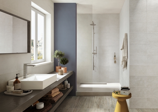 Bagno minimalista moderno con doccia. effetto pietra e cemento sui toni del grigio