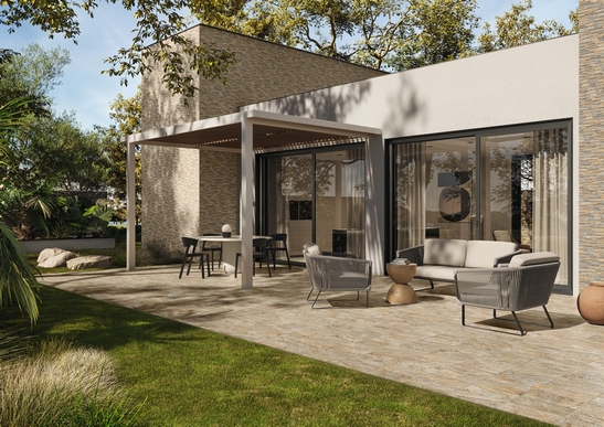 Terrasse moderne, sol en grès cérame imitation pierre beige, tons chauds.