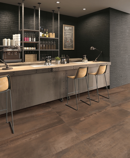 Modern restaurant bar with brown metal-effect stoneware flooring for an industrial touch
