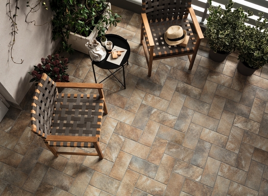 Balcon rustique dans des tons chauds, sol en grès cérame effet quartzite gris.