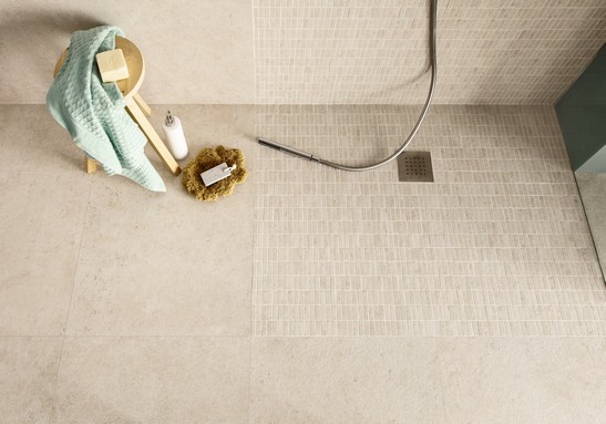 Modern bathroom with beige stone-effect mosaic shower wall tiles