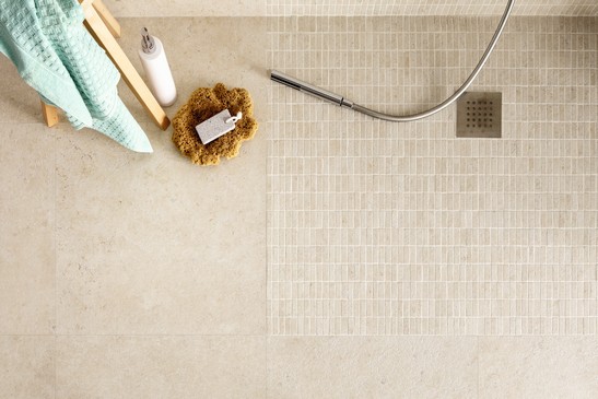 Bagno moderno con doccia, pavimenti effetto pietra beige