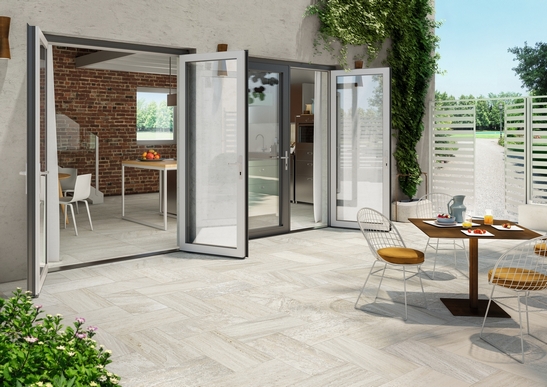 Terrasse moderne avec sol en grès cérame effet pierre claire.