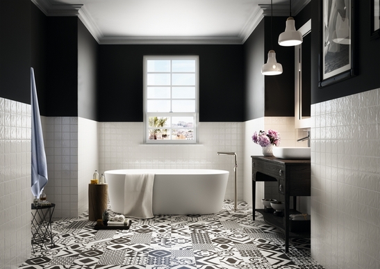 Salle de bains vintage avec baignoire. Carreaux de ciment en noir et blanc pour une touche moderne.