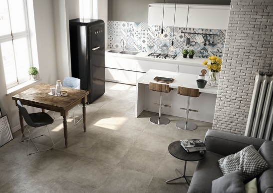 Cucina moderna con penisola effetto cemento con toni del grigio, bianco e blu per tocco industriale